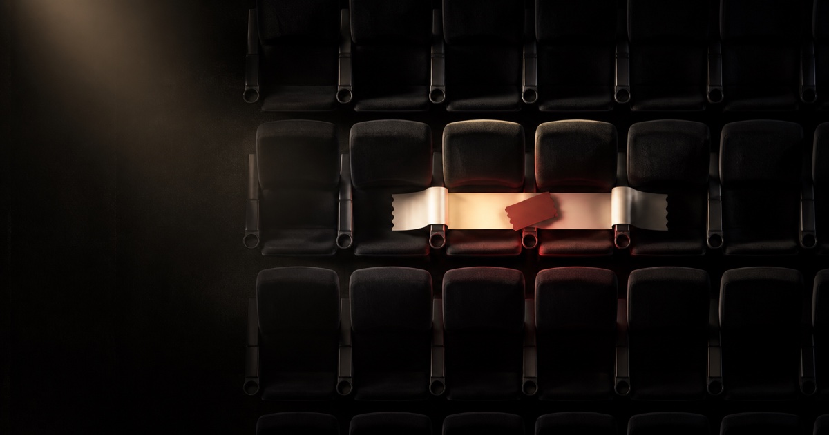 A pair of cinema seats secured by a cream claim ribbon and red ticket